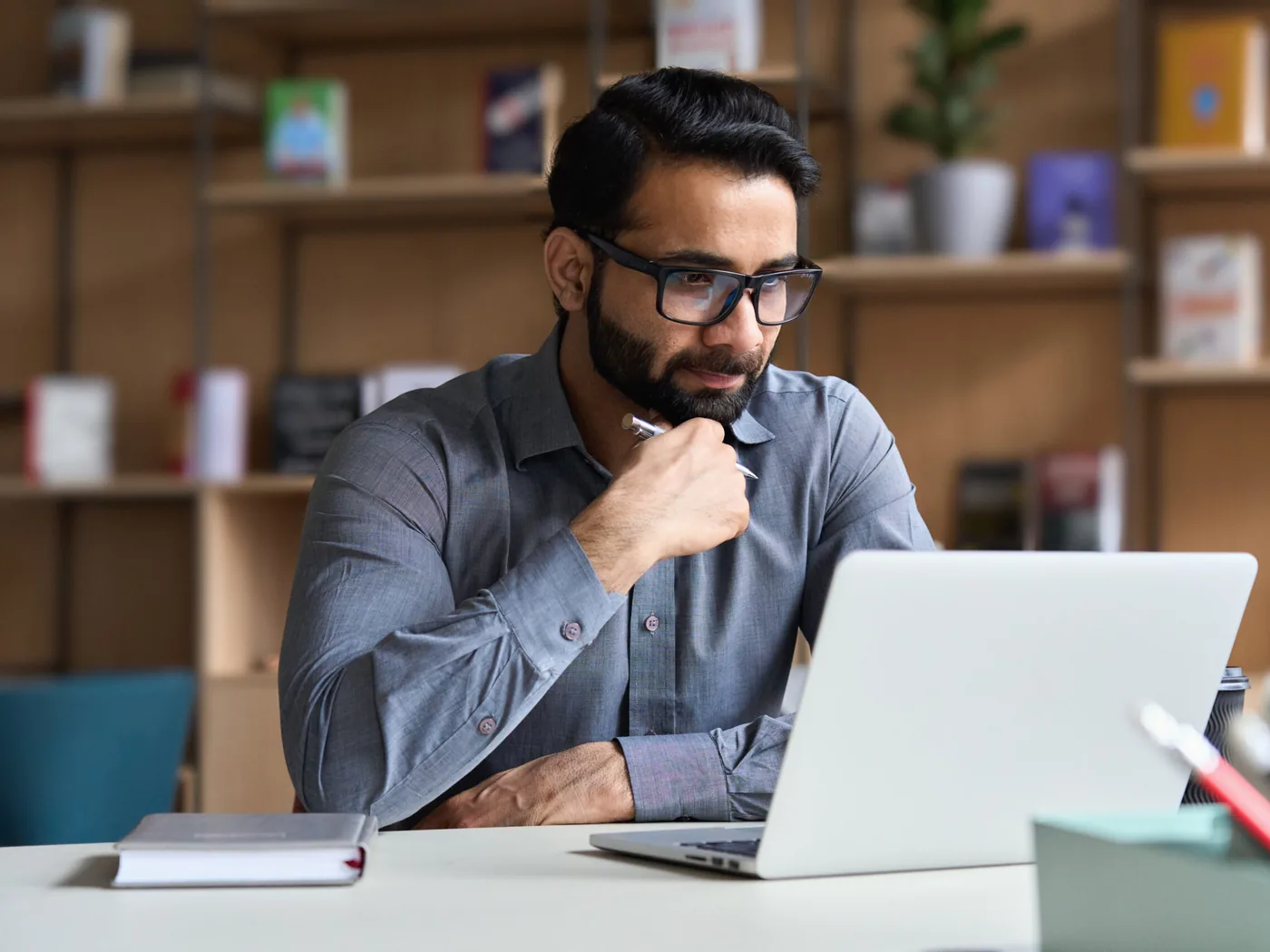 A legal professional at a desk, watching a course recording on a laptop.