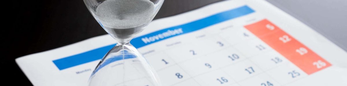 Time passing concept, time slipping away. Hourglass and the calendar