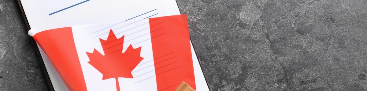 Visa application form, stamp and Canadian flag on table. Concept of immigration