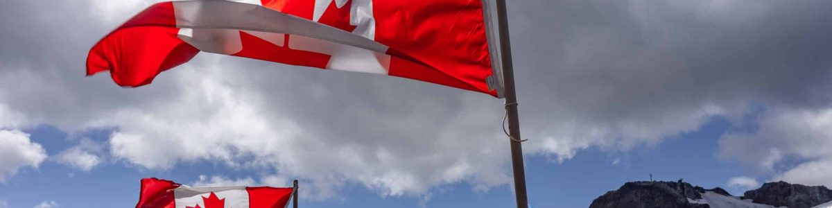 A breathtaking shot of Canadian flags flying at top of Whistler Mountain, BC, Canada