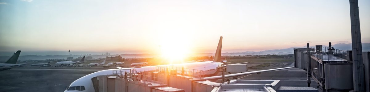 A beautiful shot of an airplane at the station with the sun shining in the background