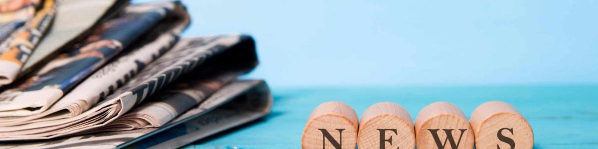 news word on wooden cube and newspapers