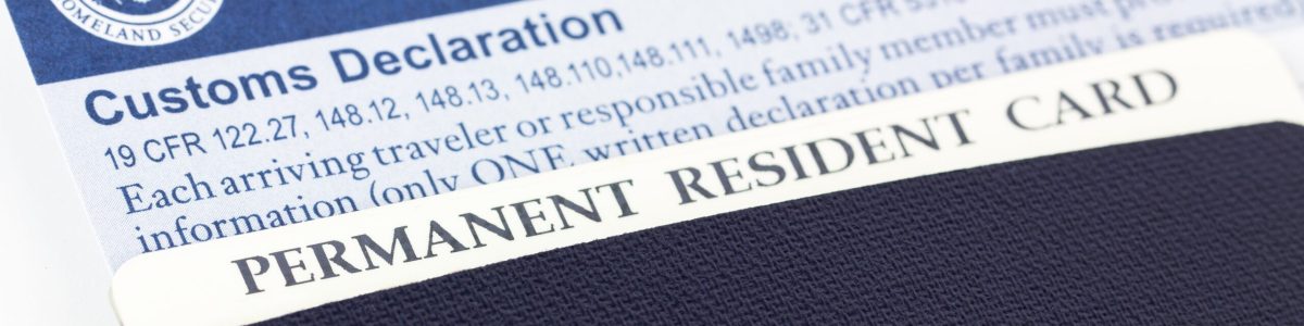 Close up of Canadian passport, permanent resident card,  and customs declaration form, some of the paper work required for each entry into the United States.