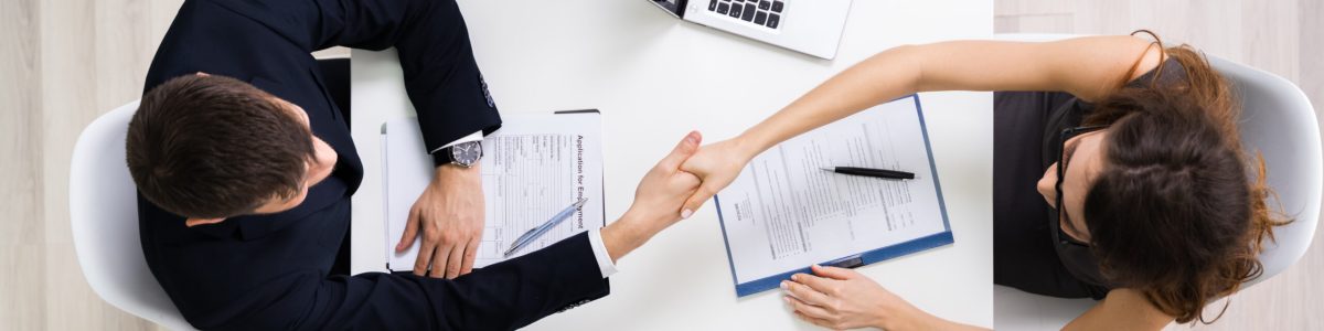 Portrait Of Two Happy Businesswoman Having Handshake In Office